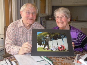 Chris and Meis Petter with a photo of him placing flowers on Canadian war graves.